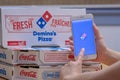 Close up of a person using the DominoÃ¢â¬â¢s Pizza application on an iPhone Plus. DominoÃ¢â¬â¢s Pizza